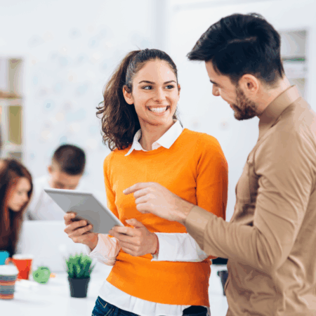 Echanges entre un homme et sa collaboratrice tenant un document en main.