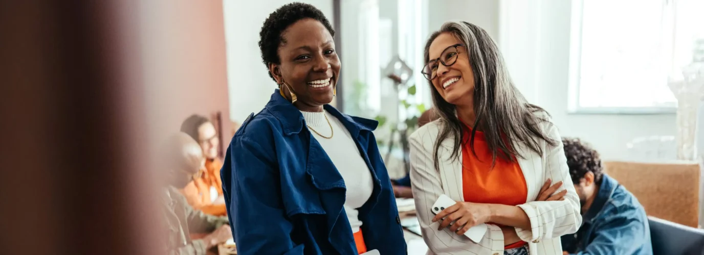 Deux collègues féminines sourient et rient ensemble
