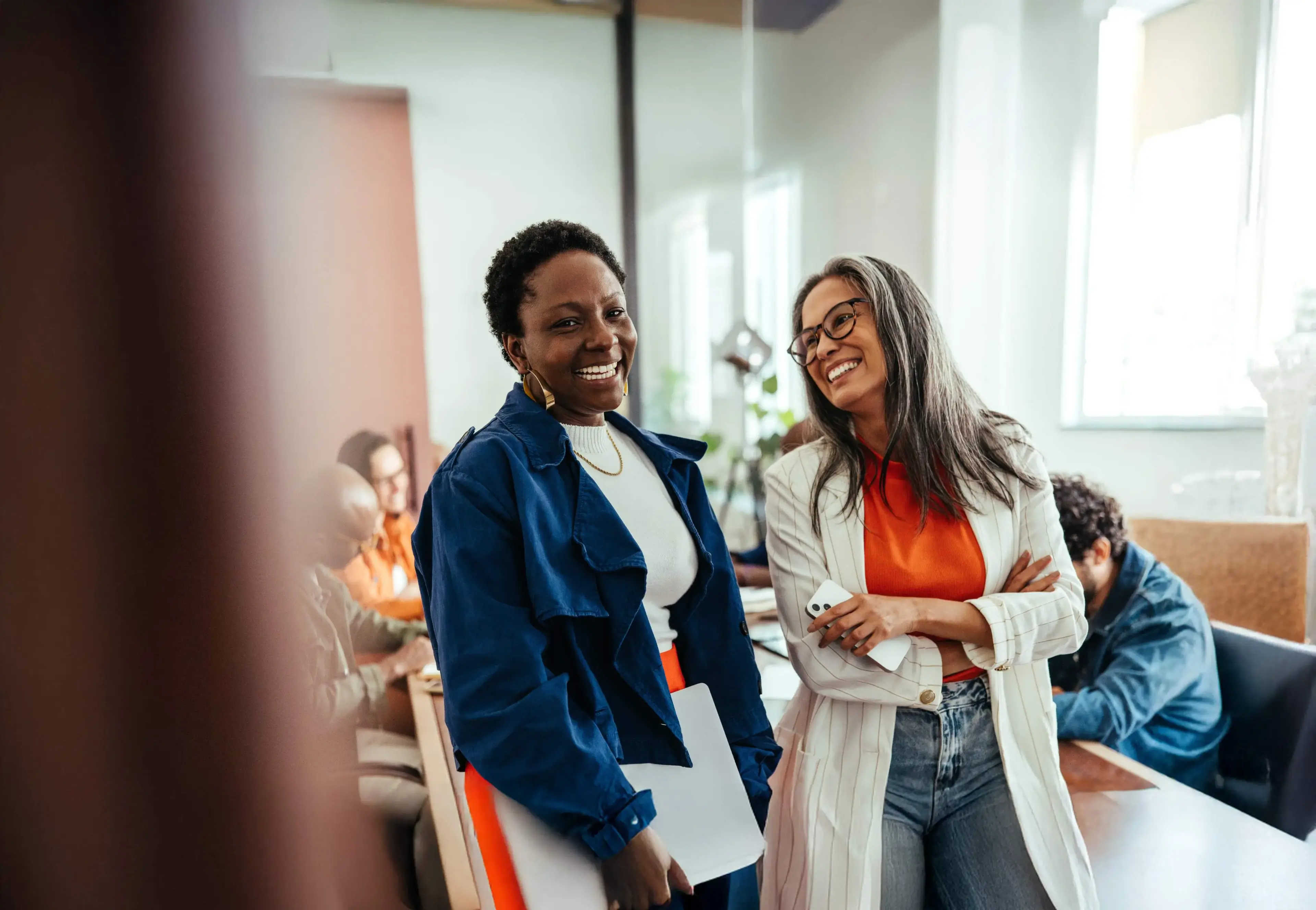 Deux collègues féminines sourient et rient ensemble