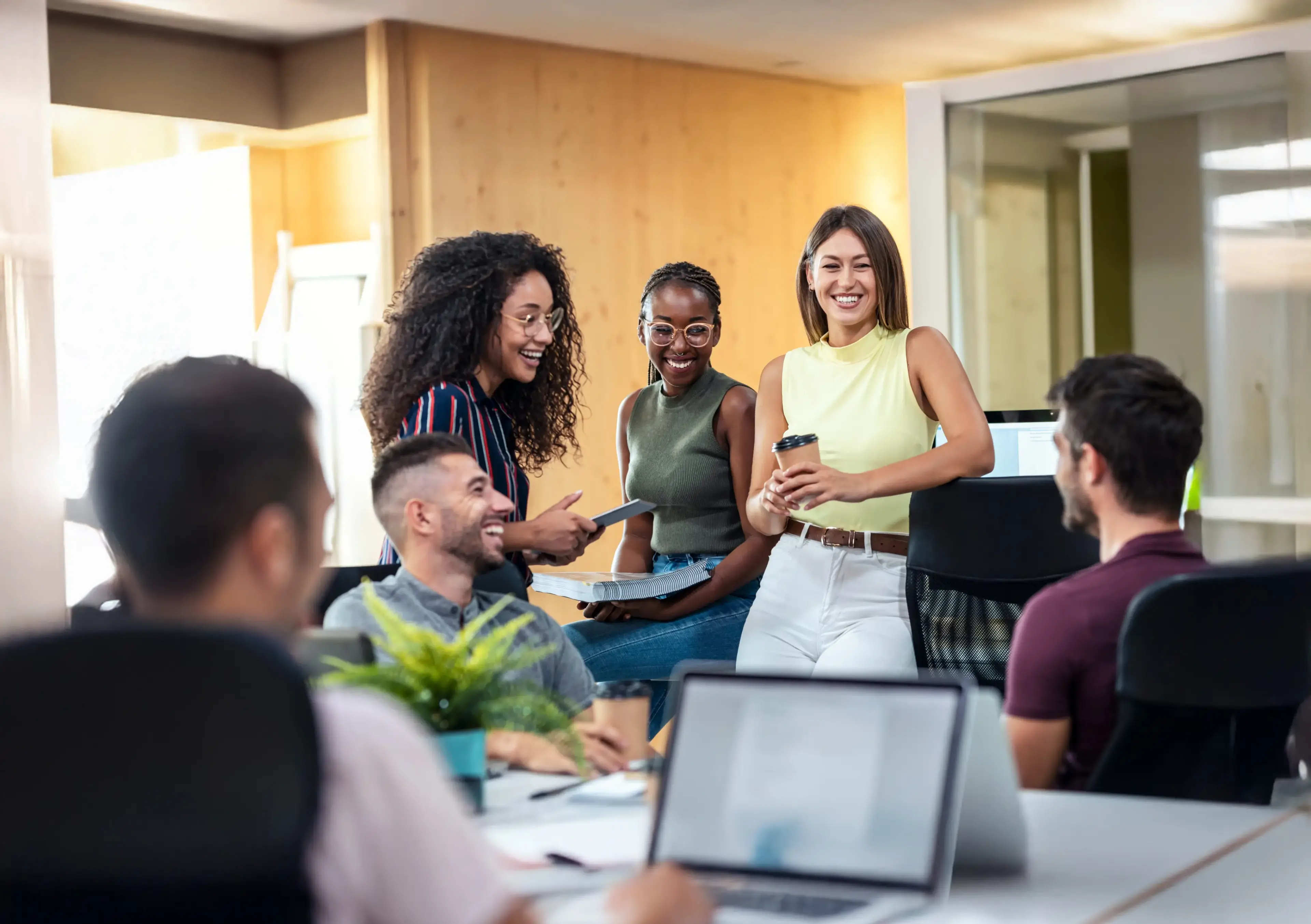 Echanges détendus entre plusieurs collègues au bureau.