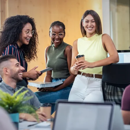 Echanges détendus entre plusieurs collègues au bureau.