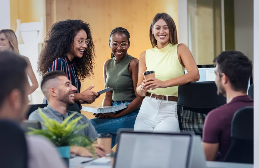Echanges détendus entre plusieurs collègues au bureau.