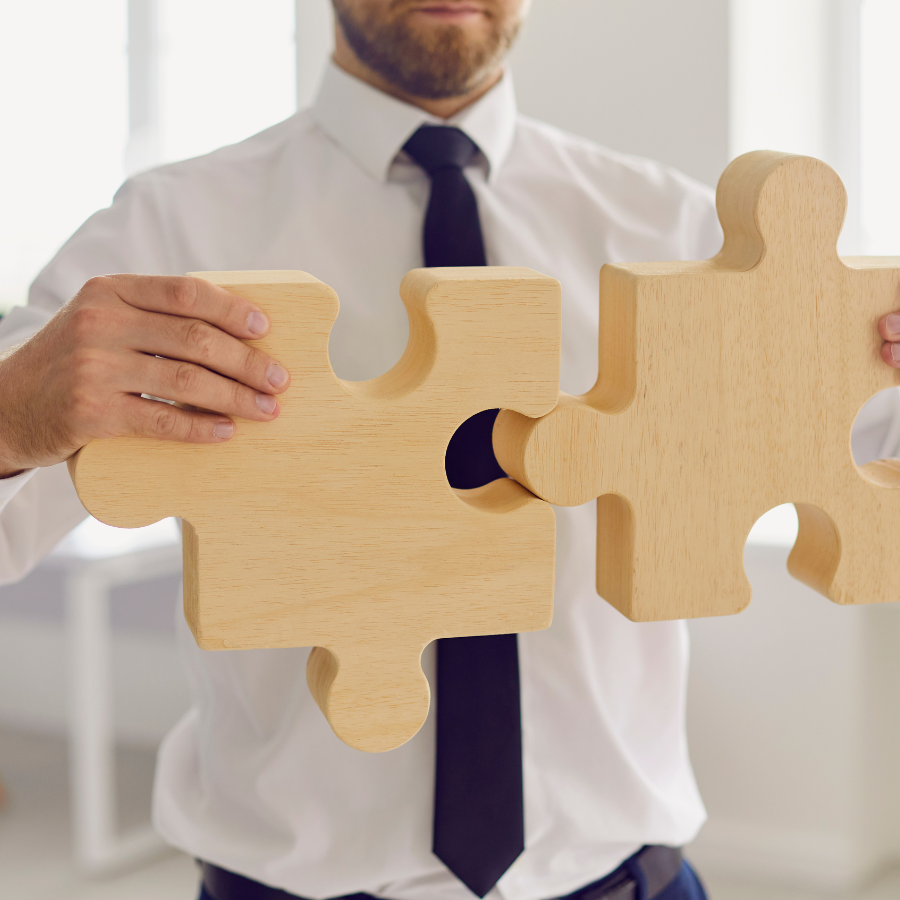 Homme emboîtant deux pièces de puzzle